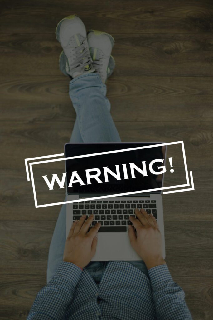 Young man sitting on floor with laptop and WARNING! concept on s Young man sitting on floor with laptop and WARNING! concept on s