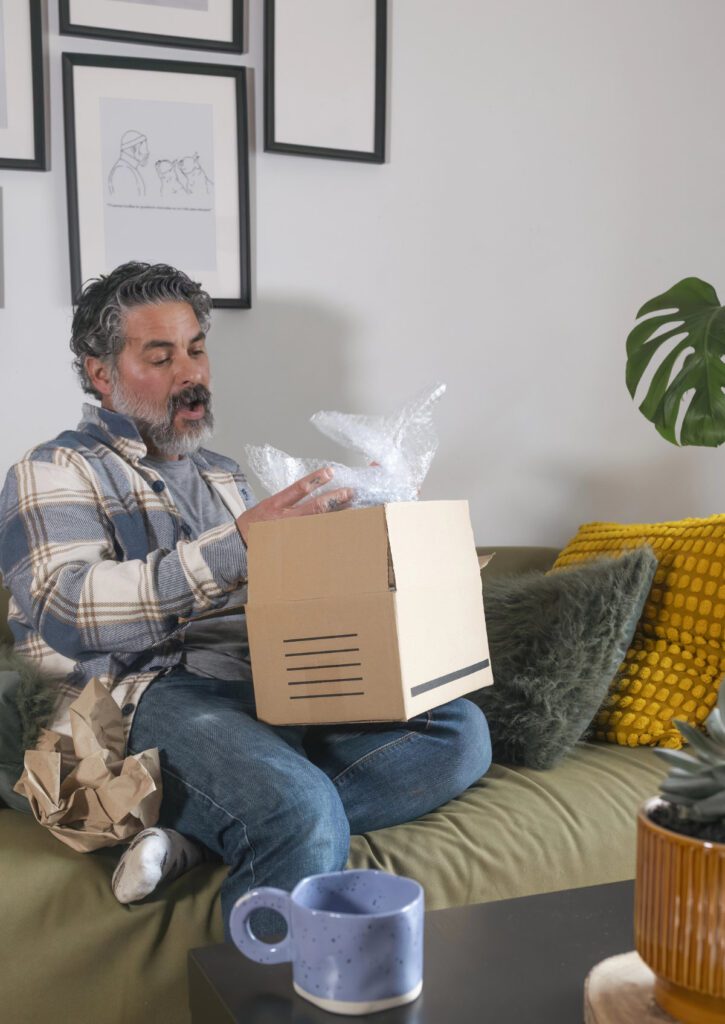 Happy customer unpacking parcel with bubble wrap, enjoying his p